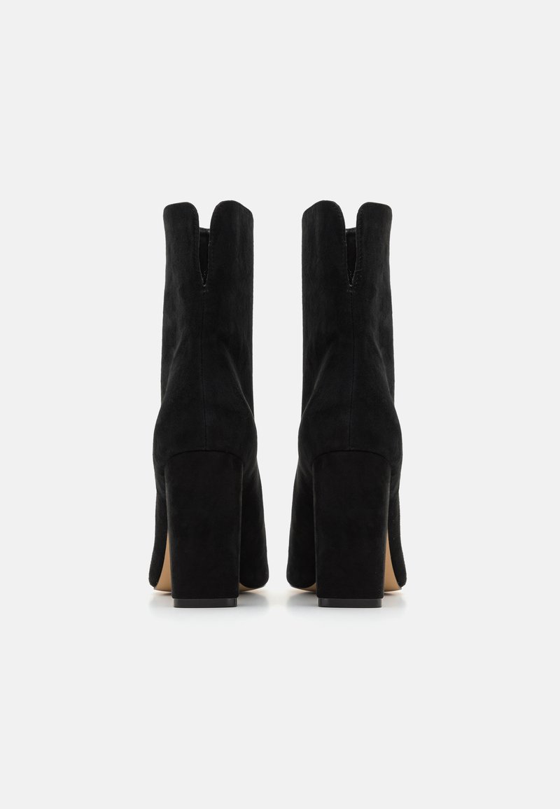 Stivali neri in suede con tacco alto, punta quadrata e design a spacco nella parte superiore. I tacchi a blocco robusti offrono stabilità e una silhouette elegante.