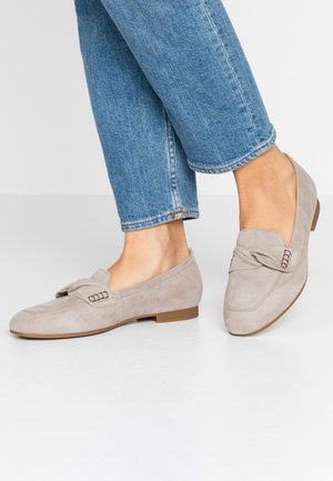Beige ruskind loafers med en lille hæl, med en sløjfedetalje og dekorativ accent foran, båret med lyseblå manchetterne jeans.
