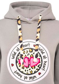 Grauer Kapuzenpullover mit einer großen runden Grafik im Leopardenmuster und pinken Herzen. Die Zugbänder sind in Schwarz und Beige gemustert.
