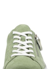 Green suede sneaker with white laces, a side zipper, and a textured finish. Rounded toe and a flat white sole complete the design.