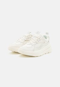 Weiße Sneaker mit einem Obermaterial aus strukturiertem Leder, gepolstertem Kragen und strukturierten Schnürsenkeln. Ausgestattet mit einer dicken Gummisohle und einer Schlaufe an der Ferse.