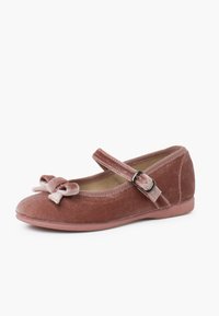 Vliesrosa Ballettschuh mit runder Zehe, der mit einer dekorativen Schleife und einem Riemen mit einer metallischen Schnalle an der Seite ausgestattet ist. Flache Sohle.