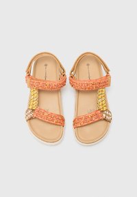 Sandales tissées orange et jaunes avec des sangles texturées, une semelle intérieure beige lisse et des accents décoratifs sur le côté. Sangle arrière réglable.
