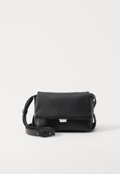 Fekete textúrájú bőrből készült crossbody táska, fedéllel, ezüstszínű fémrészletekkel és állítható pánttal. Minimalista dizájn, tiszta vonalakkal.