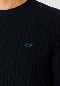 Maglione blu navy a nido d'api con scollo rotondo a coste. Presenta un piccolo logo blu ricamato sul davanti. Motivo testurizzato su tutta la superficie.