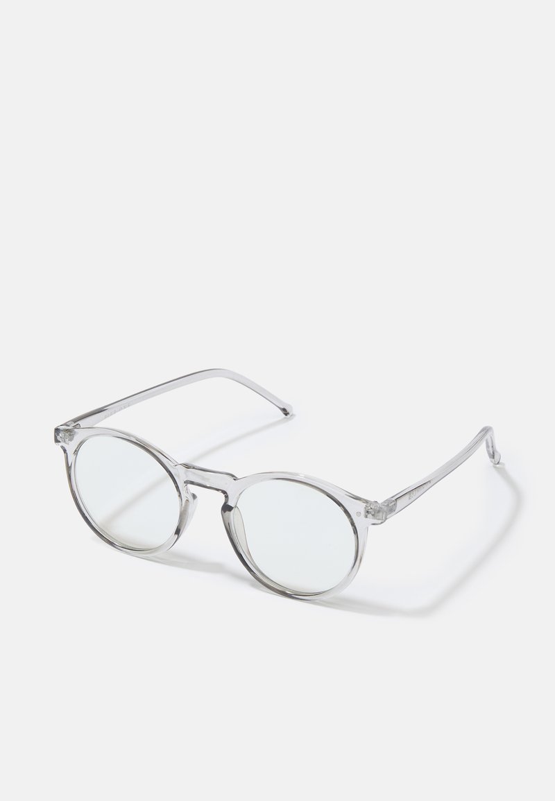 Lunettes de soleil rondes et transparentes, avec des montures transparentes, des verres sans teinte et des branches fines. Présente un design minimaliste sans embellissements visibles.