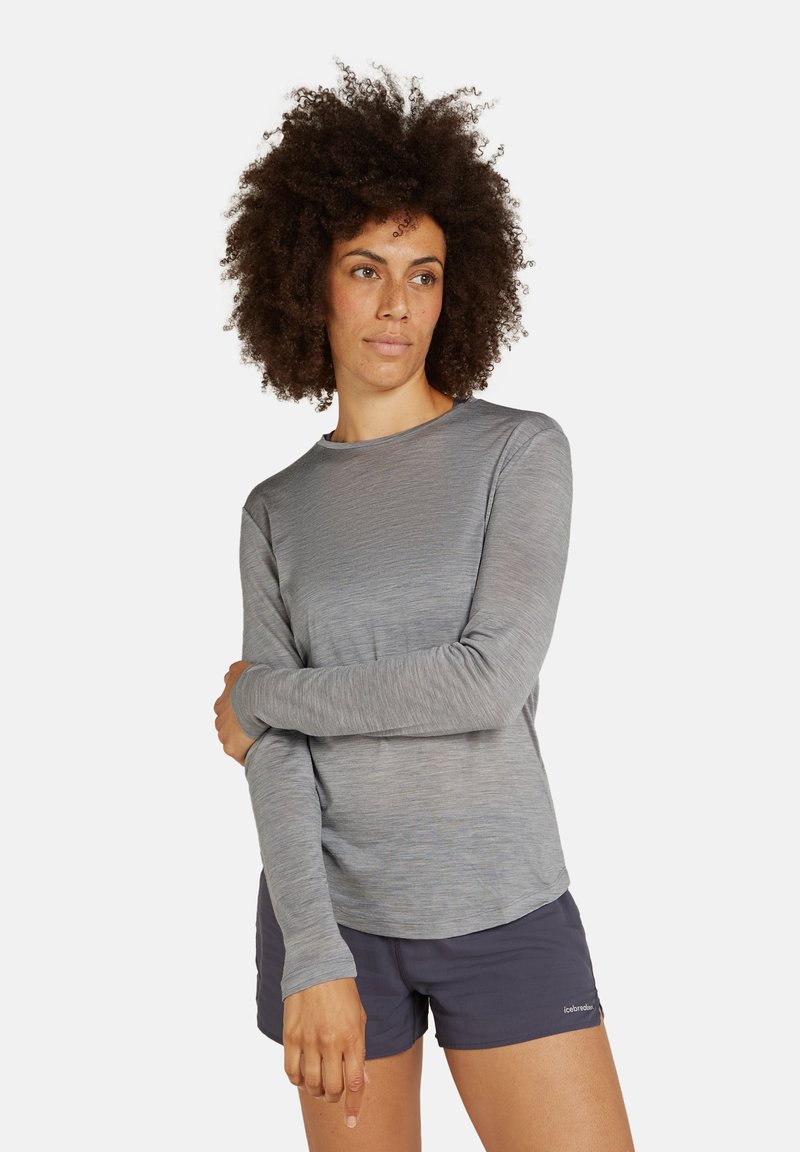 Hellgraues Langarmshirt mit Rundhalsausschnitt und strukturiertem Stoff, kombiniert mit dunklen Shorts. Verfügt über eng anliegende Ärmel und eine lockere Passform.
