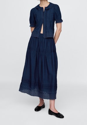 Marineblaues zweiteiliges Kleidset mit einem gemusterten gerafften Rock und einer kurzärmeligen Bluse mit geschwungenem Kragen und Lochstickerei.