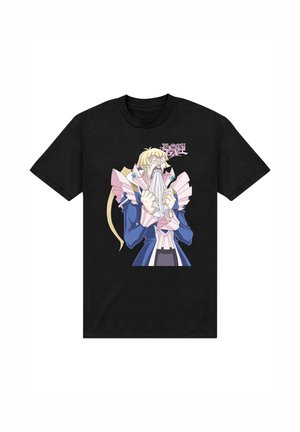 T-shirt noir avec un personnage d'anime surpris aux cheveux blonds, portant une tenue bleue et rose, mordillant un tissu blanc, avec le texte « Yu-Gi-Oh! GX » au-dessus.