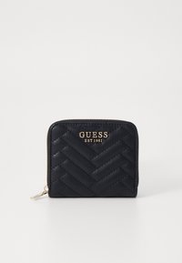 Portefeuille noir matelassé avec un motif tissé, logo doré "GUESS EST 1981" à l'avant et fermeture zippée. Texture lisse.