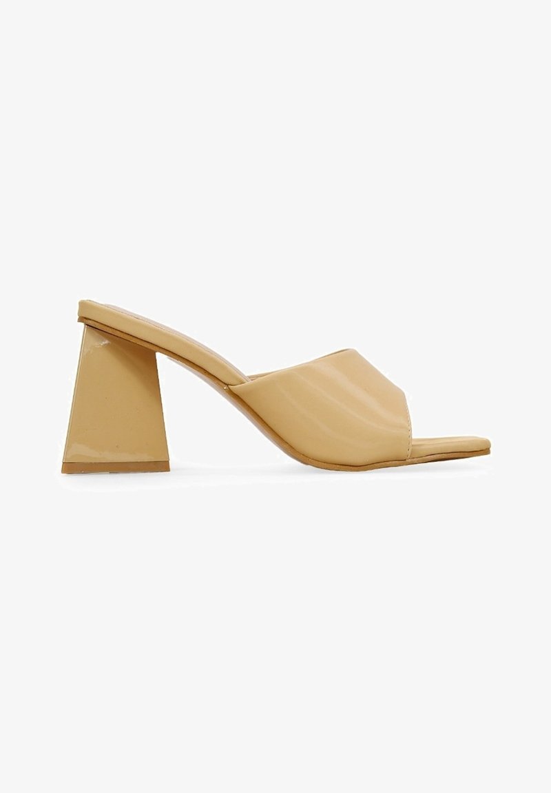 Sandale mule beige à bout ouvert avec une large bride avant et un talon bloc trapézoïdal épais.