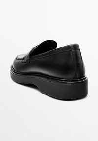 Black leather slip-on shoe with a rounded toe, padded collar, and thick sole; smooth texture with minimal stitching details.