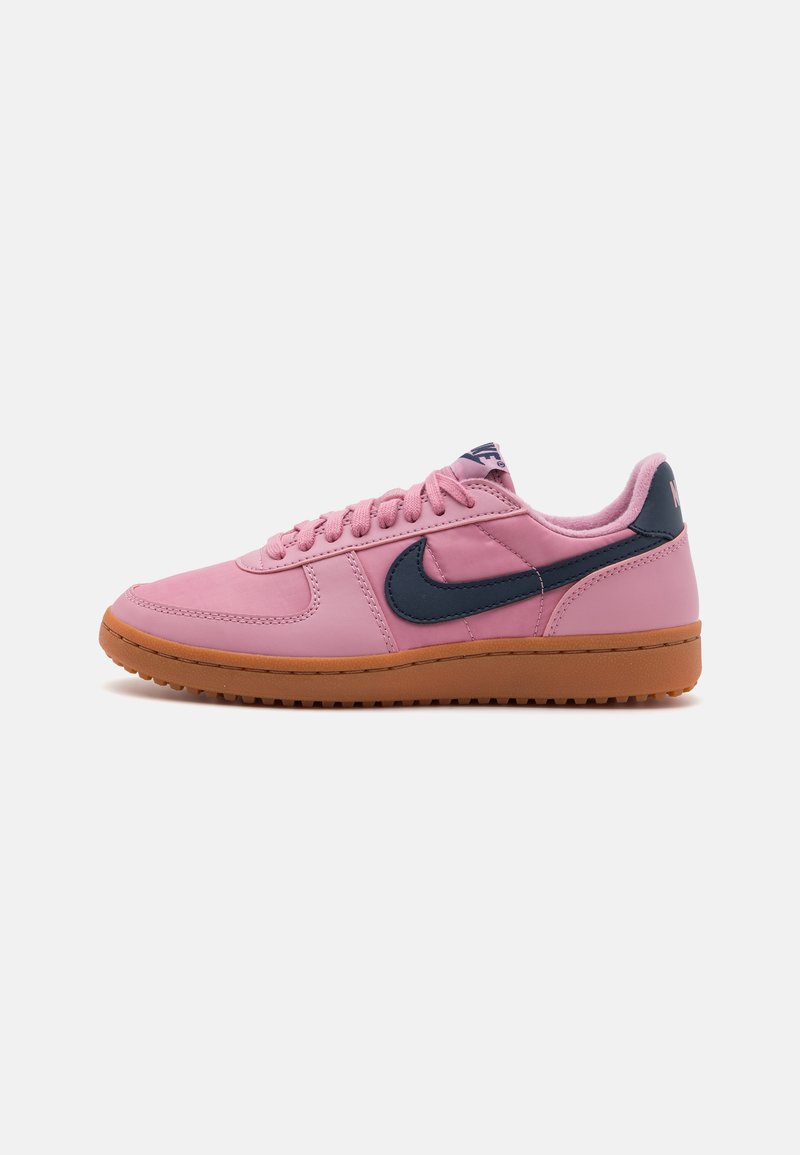 Nike-sko med en rosa syntetisk overdel, marineblå detaljer og en teksturert gummisåle. Har snøring og merket tunge.