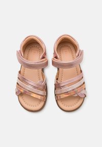 Lyserøde sandaler med blanke syntetiske stropper, gennemsigtige detaljer og en struktureret indersål, samt en sikker velcro-lukning.