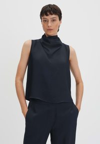 Top senza maniche in navy con scollo alto e vestibilità rilassata. Realizzato in tessuto morbido, presenta un design minimalista e senza chiusure visibili.