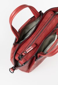 Borsa a mano in pelle rossa con finitura testurizzata, dotata di chiusura con zip superiore, fodera interna a righe e manico corto.