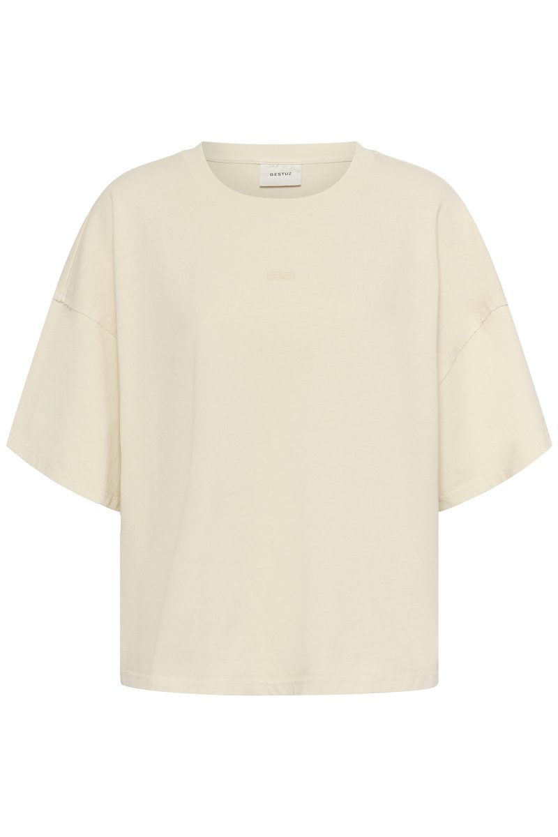 Cremfarbenes, oversized T-Shirt aus weicher Baumwolle, mit rundem Halsausschnitt und breiten kurzen Ärmeln, versehen mit dezent geprägtem Branding auf der Vorderseite.