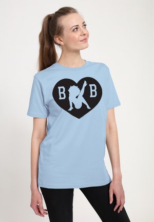 Lyseblå bomulds T-shirt med et sort hjerte grafik, der har bogstaverne "B B" og en silhuetdesign i midten. Korte ærmer.