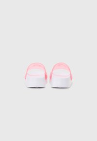 Sandales à glissière roses et blanches avec une texture lisse, un design minimaliste, une forme arrondie et une sangle arrière pour un ajustement sécurisé.