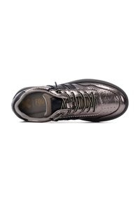 Zapatilla de deporte plateada metálica con un acabado texturizado, que presenta detalles en negro, cordones redondos y perforaciones en la puntera.