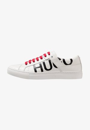 Bílé kožené tenisky s plochou podrážkou, černým logem "HUGO" na boku a červenými tkaničkami, s hladkou texturou a minimalistickým designem.