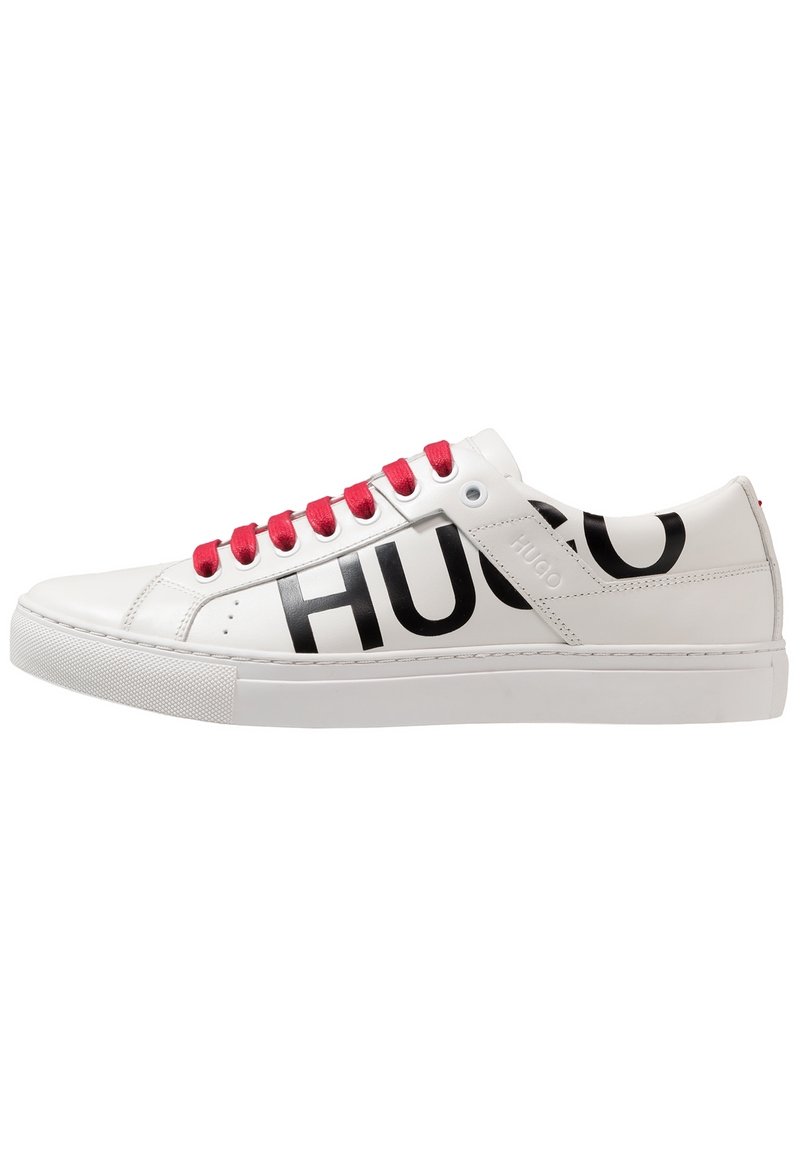 Baskets blanches en cuir avec une semelle plate, logo "HUGO" noir sur les côtés et lacets rouges, présentant une texture lisse et un design minimaliste.