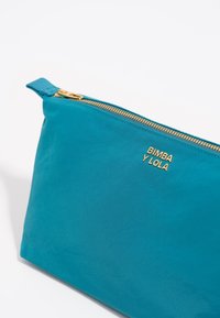Funda de tela verde azulado con cremallera dorada y el logo "BIMBA Y LOLA". Forma rectangular, textura suave y diseño resistente. Ideal para accesorios.