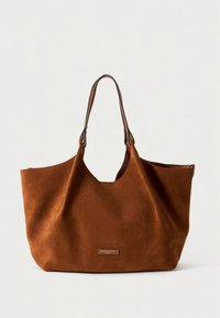 Brun semsket skinn handlenett med romslig design og to brune lærhåndtak. Har en diskret logopatch på forsiden.