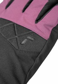 Winterhandschuh mit schwarzem Grund und einer lila, strukturierten Oberseite. Auffällige Naht und ein geometrisches Muster im Bereich des Handgelenks.