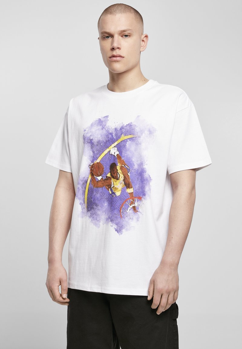 Hvit bomull t-skjorte med et fargerikt grafikk av en basketballspiller i luften, med lilla akvarell aksenter og detaljer av en kurv.