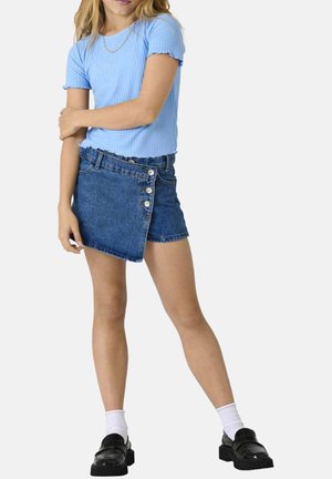 Un haut côtelé bleu clair à manches courtes associé à une jupe en jean taille haute avec un ourlet diagonal et une patte de boutonnage à cinq boutons. Des mocassins noirs et des chaussettes blanches.