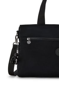 Schwarze Nylon-Schultertasche mit einem Reißverschlusspunkt, verstellbarem Tragegurt und einem charm in Form einer schwarzen Figur. Auf der Vorderseite befindet sich ein Logodetail.