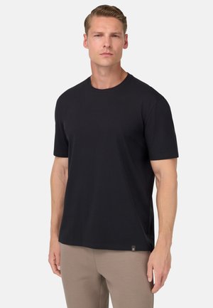 T-shirt in cotone nero con maniche corte, scollatura rotonda e un piccolo etichetta con il marchio in fondo. Tessuto liscio, vestibilità comoda.