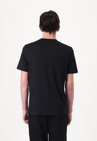 Black cotton t-shirt with a crew neck and short sleeves, featuring a simple design and a smooth texture. Back view only, minimal details visible.