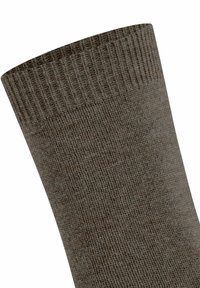 Primo piano di un polsino di una calza a costine marrone che mostra la texture e la fascia elastica nella parte superiore.