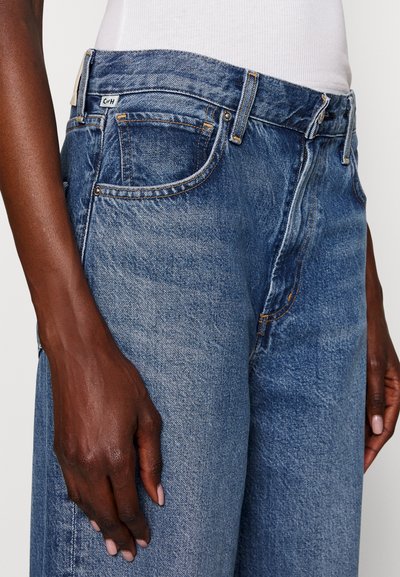 Denim jeans i middels blå med en avslappet passform, med kontrastsøm, fem lommer og en label på bakgjerde.