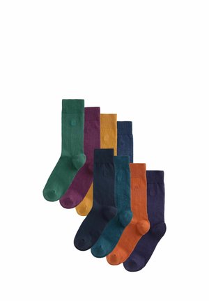Mischung von Socken in acht Paaren in verschiedenen Farben: grün, lila, gelb, dunkelblau, teal, orange und dunkelmarine. Hergestellt aus strukturiertem Material.