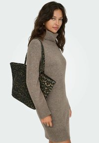 Tote torba s uzorkom leoparda, strukturiranog oblika, u crnim i smeškastim nijansama, od mekog materijala, s čvrstim ručkama, u kombinaciji s taupe pletenom haljinom.