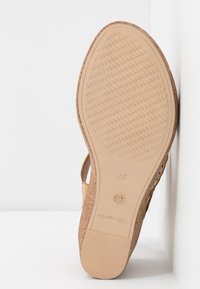 Semelle d'une sandale compensée marron avec une semelle extérieure texturée, taille 37, et le nom de la marque visible sur la partie du talon.
