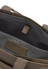 Open taupe draagtas met binnenvak met ritssluiting, kliksluiting, gestikt label met reliëftekst en dubbele schouderriemen.