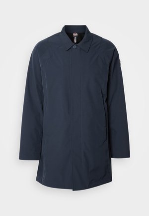 Marineblauwe, waterdichte jas met een kraag, knoopsluiting en lange mouwen. Heeft een strak ontwerp en minimalistische stiknaad.