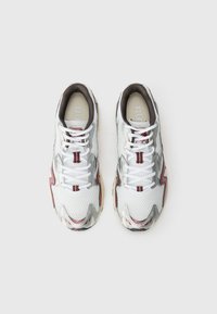 Sport sneakers featuring a white mesh upper with silver accents and maroon detailing, rounded toe, and flat white laces. Thin padded collar.