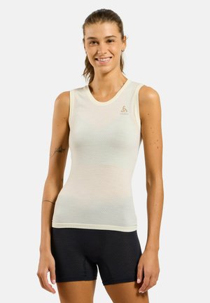 Lightweight, sleeveless top in pale cream with a textured pattern, paired with black athletic shorts. Features a round neckline and logo detail.