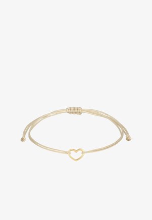 Auksinė širdelė kabina ant plono kreminio siūlo, su reguliuojamais slystančiais mazgais dydžiui. Paprastas ir minimalistinis dizainas.