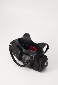 Zwarte leren handtas met meerdere voorvakjes, zilverkleurige hardware accenten en een felrode voering. Open-top ontwerp.