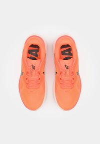 Orange Sport Schuhe mit einem Mesh-Obermaterial, schwarzen Akzenten und minimalen weißen Details. Sie verfügen über eine gemusterte Sohle und strukturierte Schnürsenkel.
