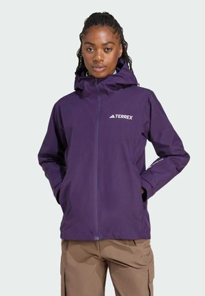 Veste imperméable violette avec fermeture éclair, capuche ajustable et accents de logo sur la poitrine et la manche. Texture lisse, design léger.
