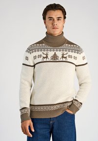 Krämfärgad polotröja med bruna mönstrade detaljer, med renar och snöflingor, strukturerad stickning och ribbade muddar och fåll.