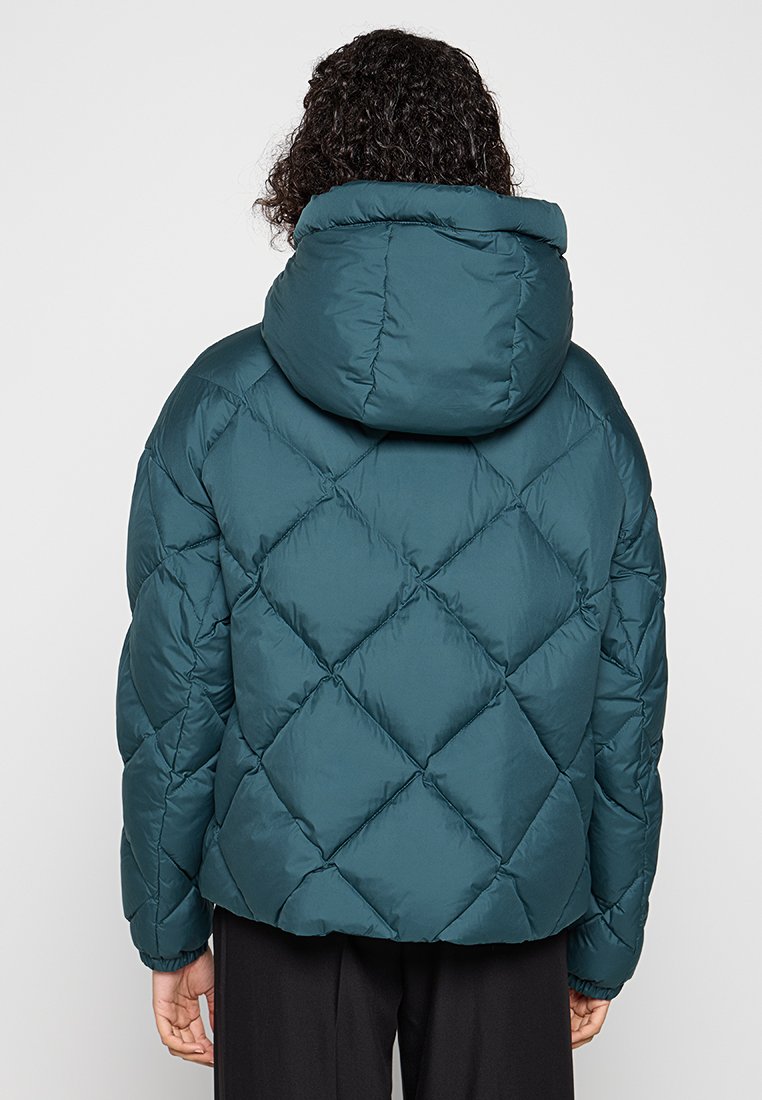 Tealowa kurtka puchowa z kapturem, z diamentowym pikowaniem. Widok z tyłu ukazuje ściągacze przy mankietach oraz miękką, gładką teksturę.