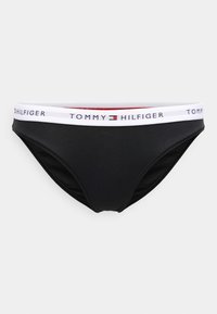 Černé bikini kalhotky s bílým elastickým páskem s logem "TOMMY HILFIGER" a červeným detailem. Hladká tkanina s přiléhavým střihem.